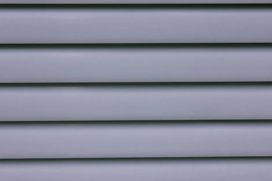 Detailed close-up of gray layered wall paneling showing lines and shadows.